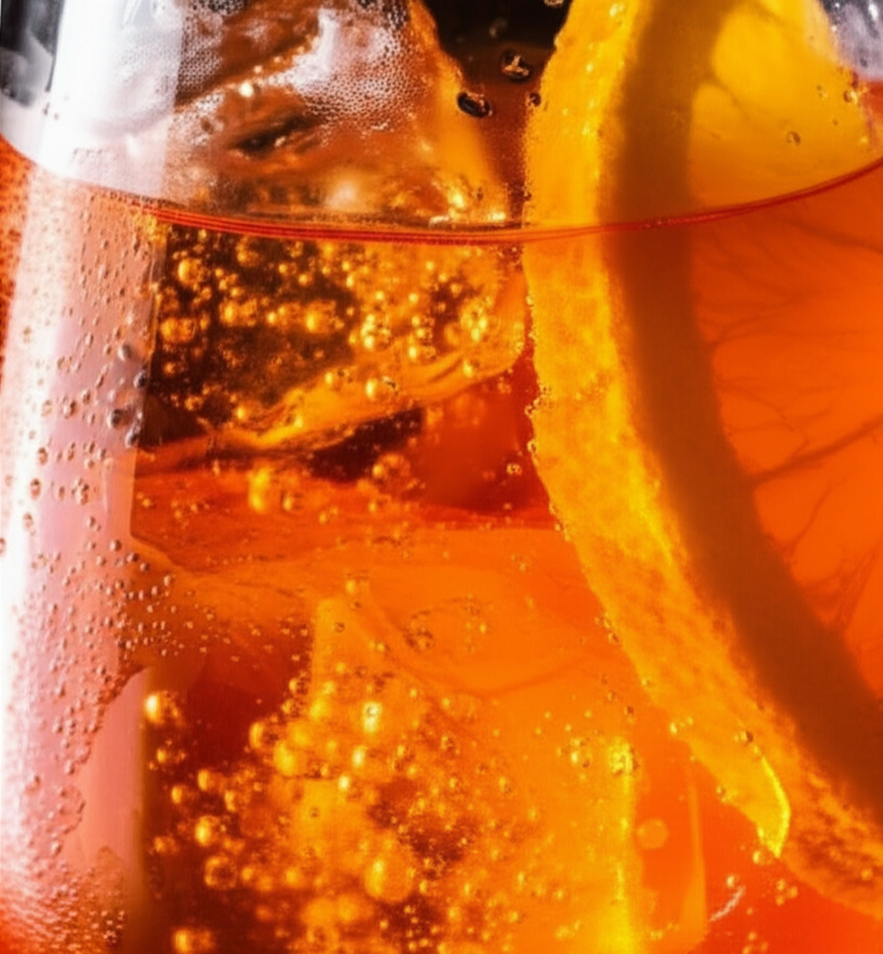 Gros plan hyperréaliste d'un Aperol Spritz, avec des détails de glace fondante, des bulles et une tranche d'orange immergée dans le liquide orange.